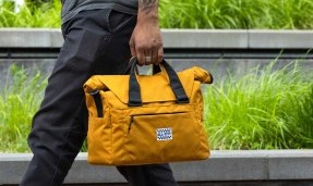 Person walking carrying Beat Box Bag using handles