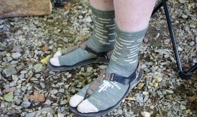 Persons feet wearing army green and tan All-City team space horse socks 