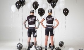 Two people showing their backs while wearing All-City black and white Wangaaa Bibs with black and white balloons around them 
