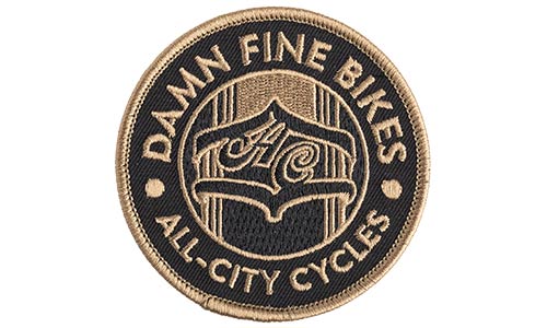 Black background, gold patch that says damn fine bikes