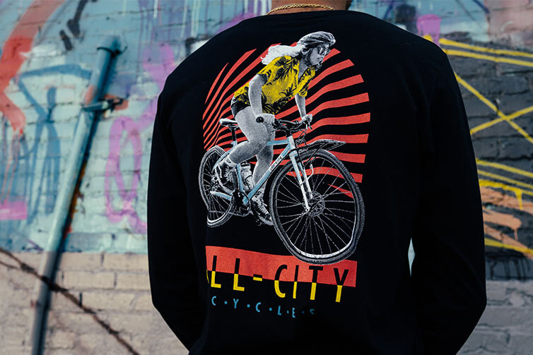 A person wearing a long-sleeve logo t-shirt with their back turned